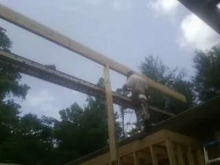 Carpenter setting a ridge beam over a new addition frame — Ice Dam Removal by Roofing Brothers in Jeffersonton