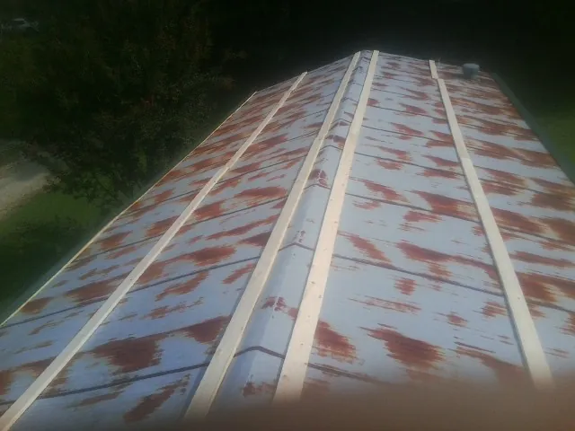 Rusted metal roof panels with new wood purlins before replacement — Storm Damage Roof Repair in Jeffersonton by Roofing Brothers