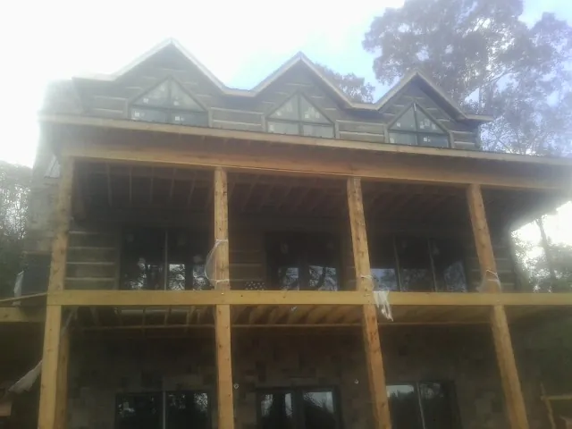 Dormers and porch framing on a large log home under construction — Roof Coating work by our crew in Jeffersonton